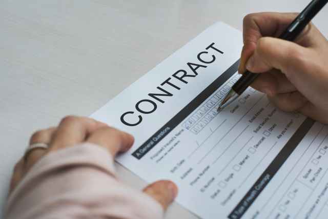 person signing contract paper